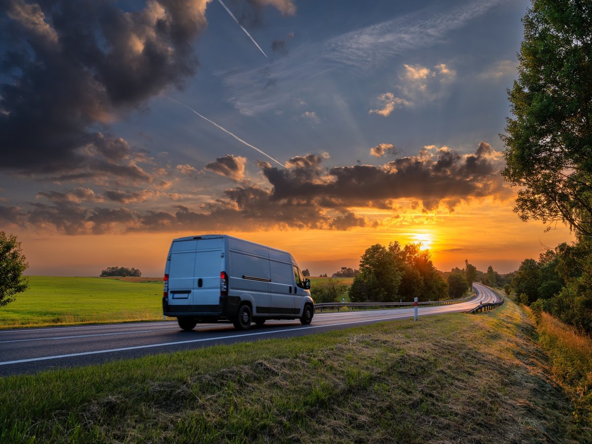 Van de reparto en carretera al atardecer